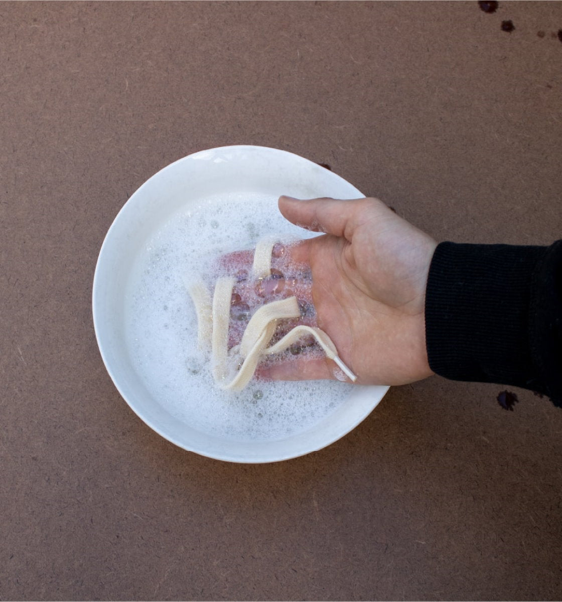 Washing Orba Ghost Sneaker laces in soapy water